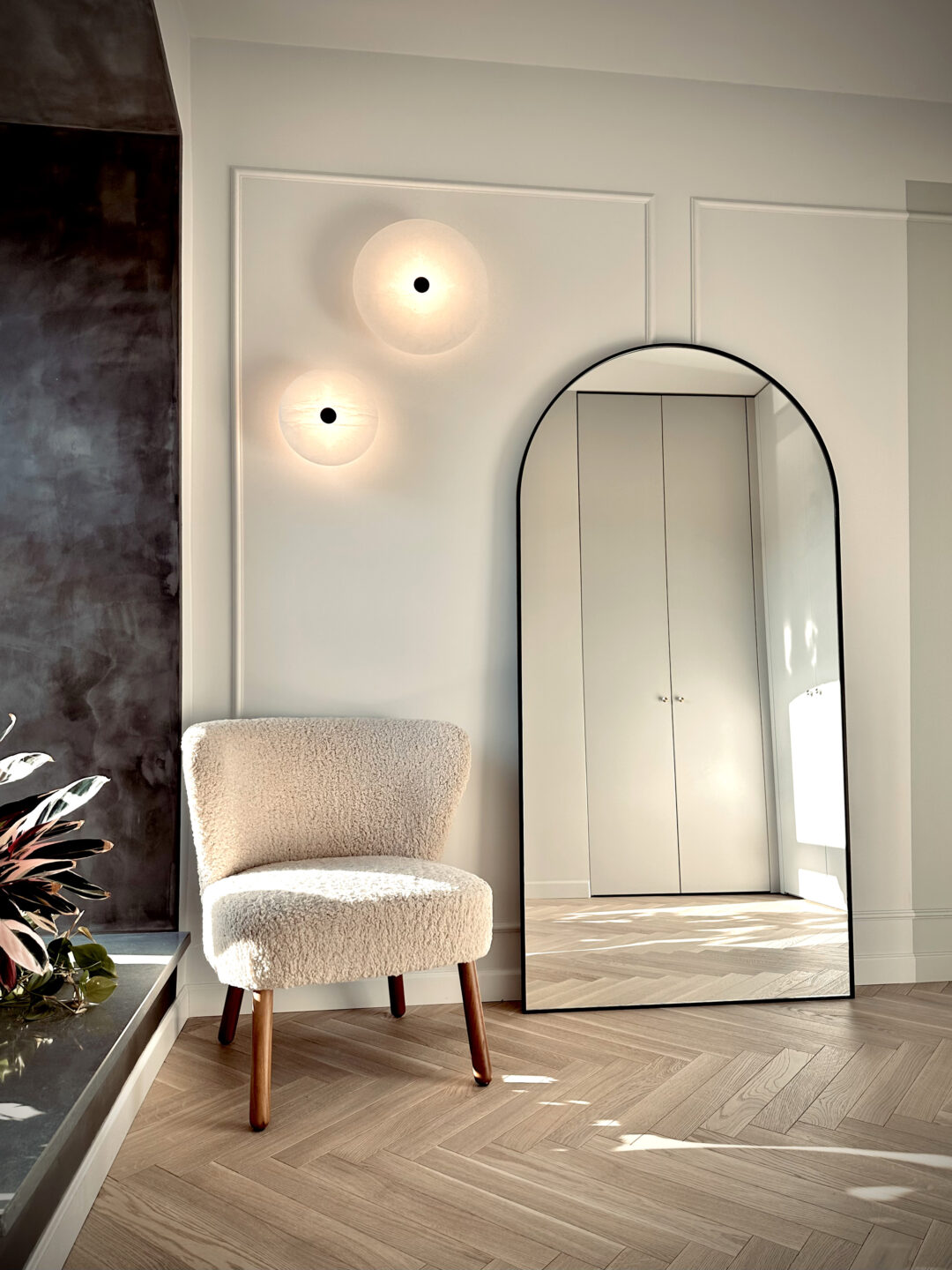 duże lustro arkadowe w czarnej ramie oparte o ścianę