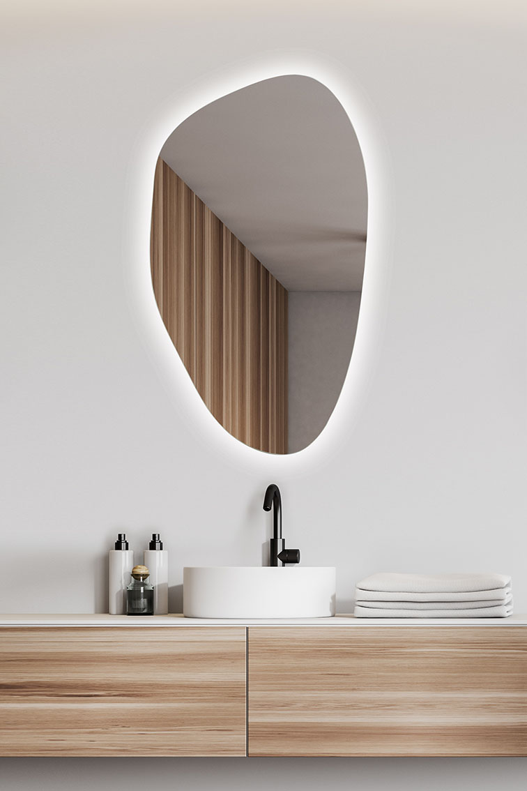 lustro w kształcie organicznym pionowe nad umywalką w białej łazience
