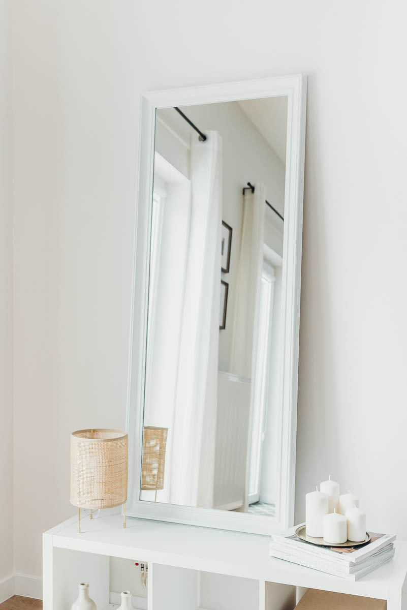 Lustro w białej ramie stojące na szafce
