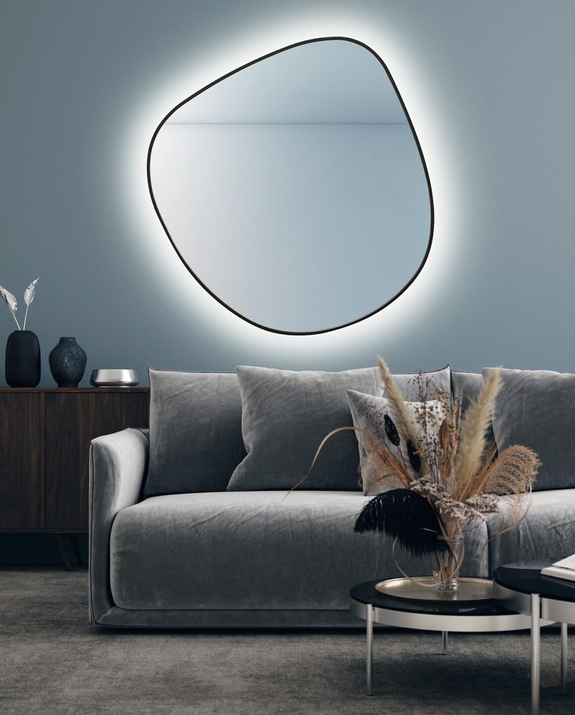 lustro Buli w czarnej ramie podświetlane w salonie nad szarą kanapą