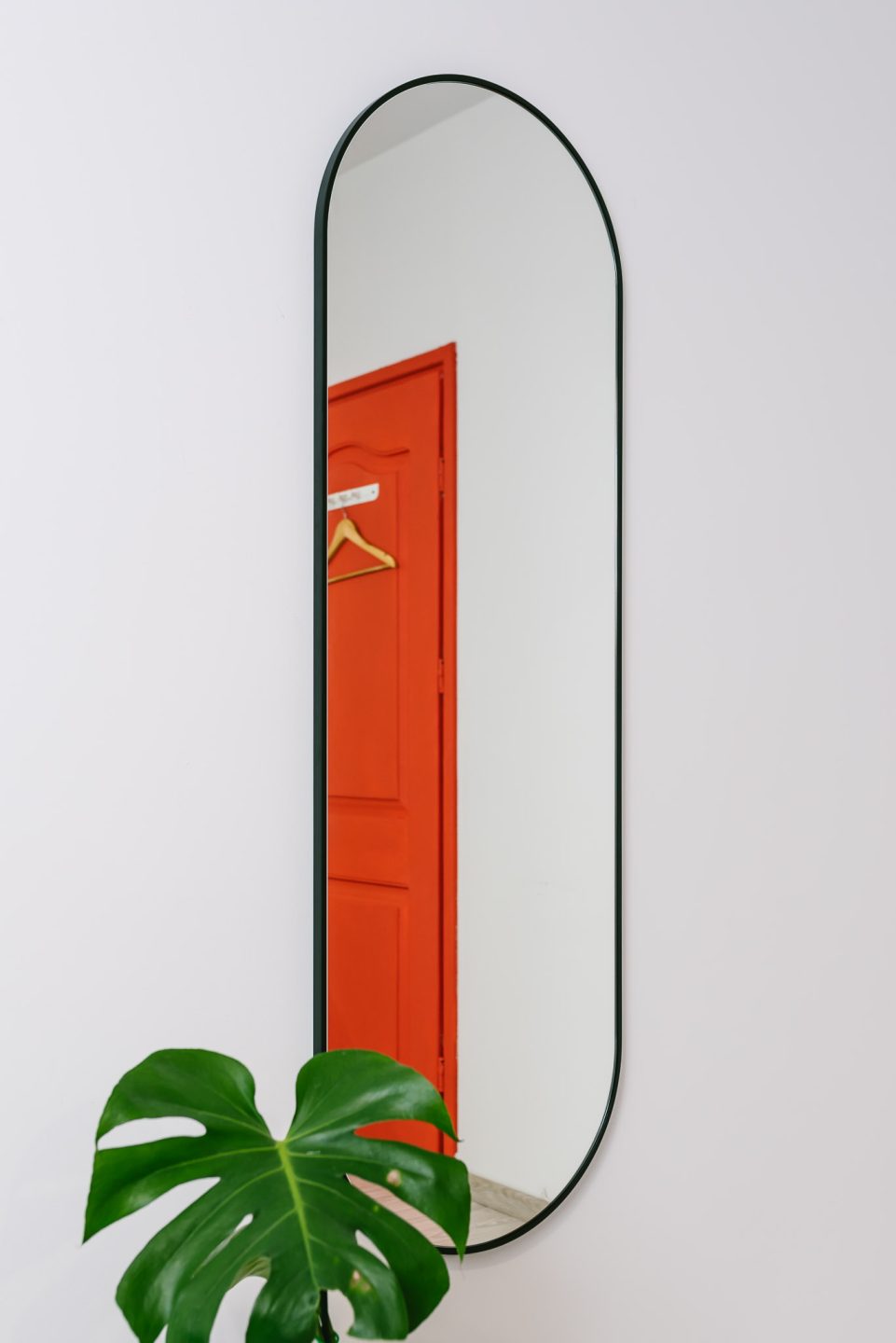 owalne lustro w czarnej cienkiej ramie w przedpokoju