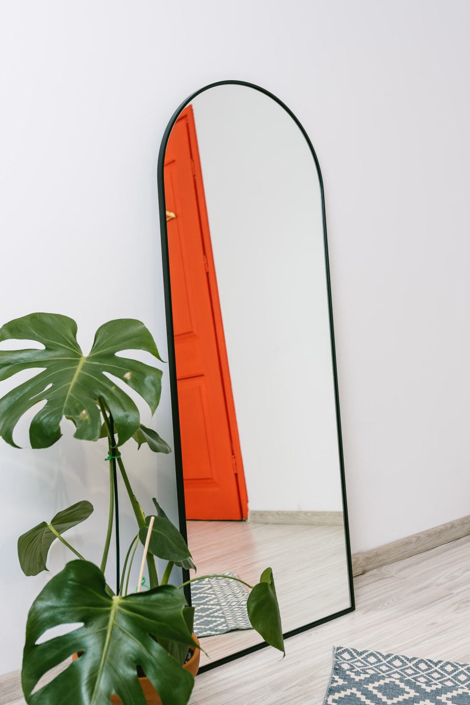 Lustro w arkadowej ramie ustawione w przedpokoju