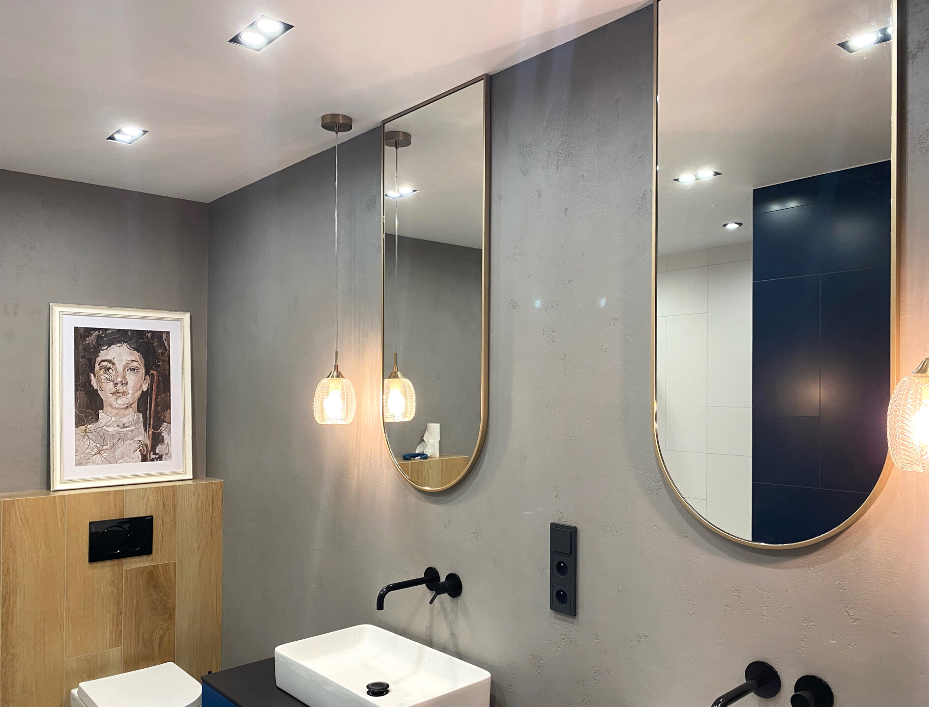 dwa lustra arkadowe w złotej ramie w łazience powieszone łukiem do dołu