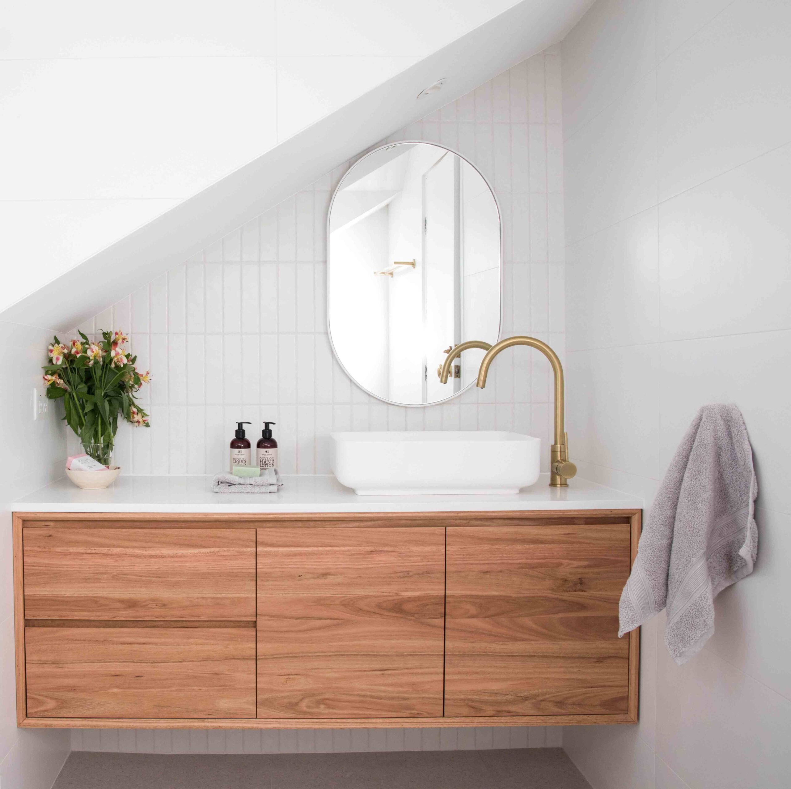 lustro owalne w bialej ramie w bialej lazience na poddaszu