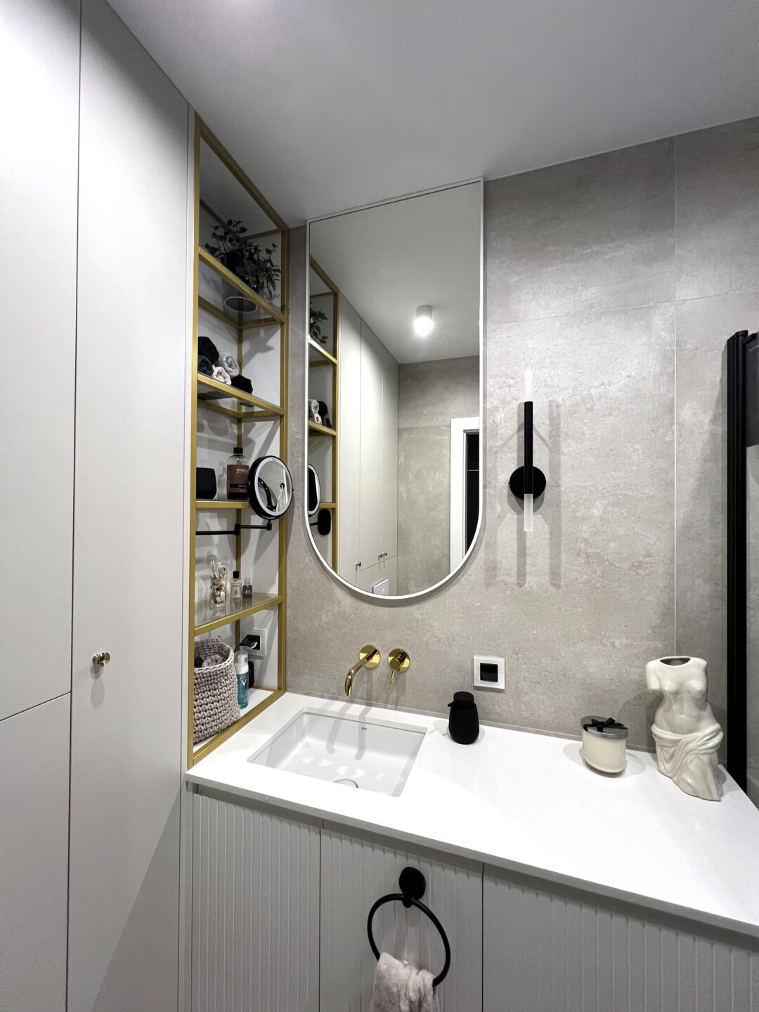 lustro z łukiem w białej ramie w szarej łazience