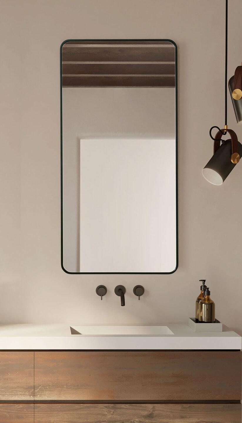 lustro w czarnej ramie z zaokrąglonymi narożnikami nad umywalką na beżowej ścianie