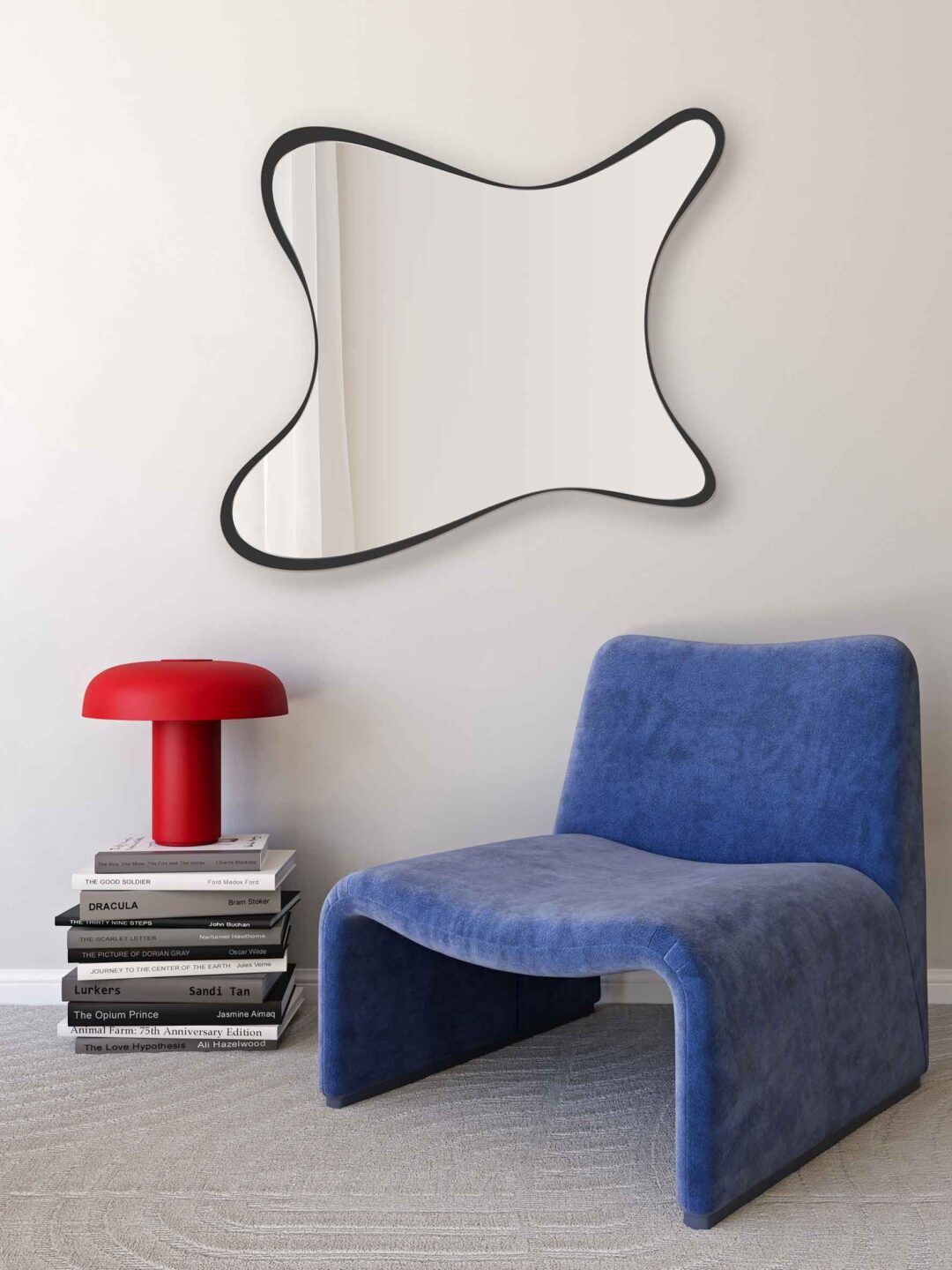 lustro splashy organiczne w czarnej nieregularnej ramie ksztaltem przypominajace rozprysk na jasnej scianie nad kobaltowym fotelem