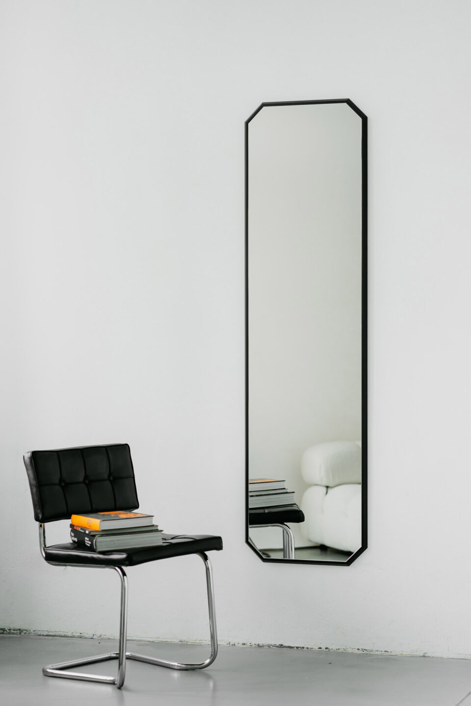 lustro diamond long w ksztalcie diamentu w czarnej waskiej ramie na bialej scianie