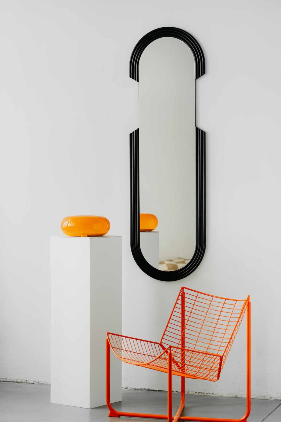 lustro owalne w stylu art deco groovie big black z czarnym ryflowanym dekorem na bialej scianie