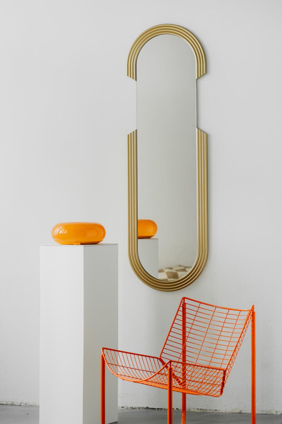 lustro owalne w formie kapsulki ze zlotymi ryflowanymi zdobieniami w stylu art deco