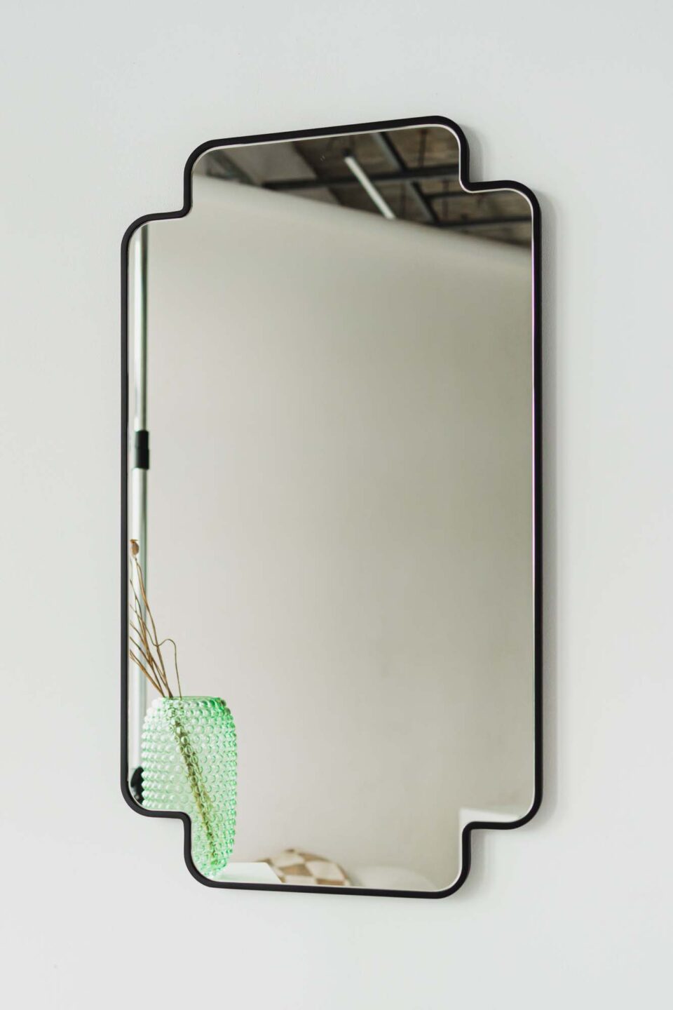 prostokatne lustro lucky clover w ksztalcie czterolistnej koniczyny w czarnej ramie na bialej scianie